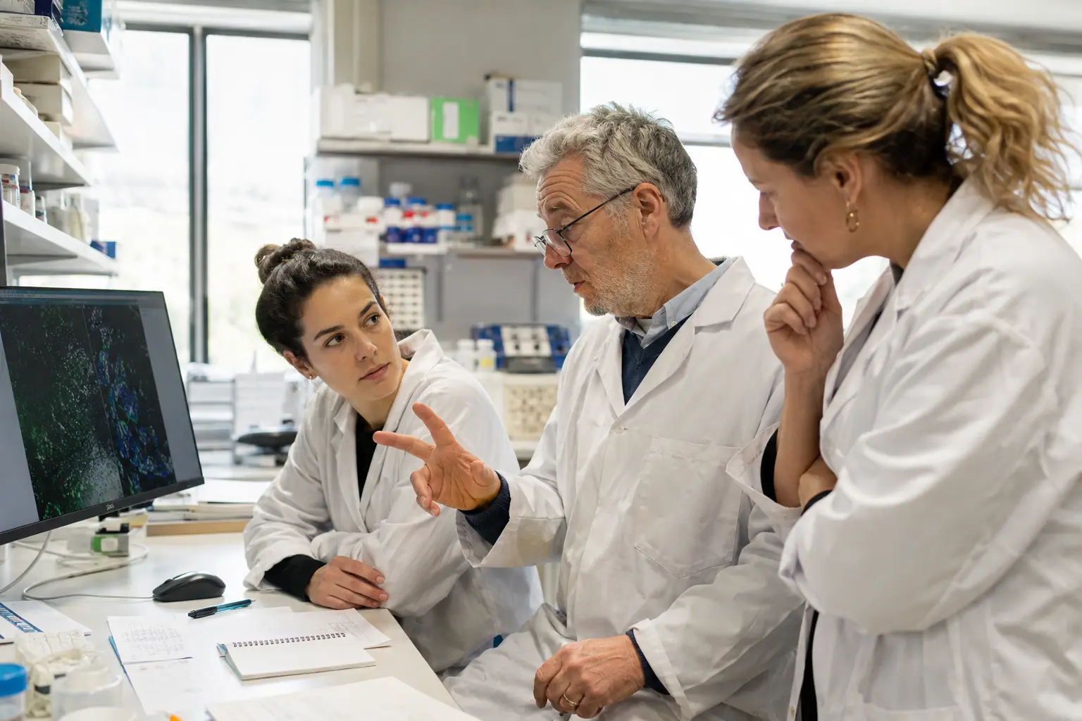 Équipe de recherche échangeant autour de résultats en laboratoire